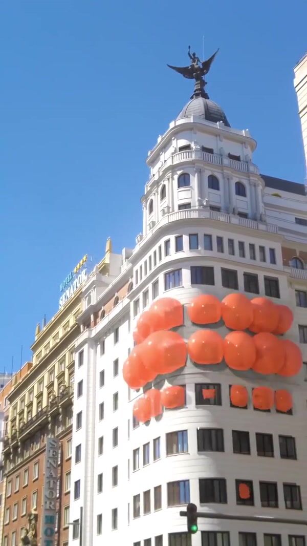 Karl Lagerfeld Orange Bag Hangs on the Building