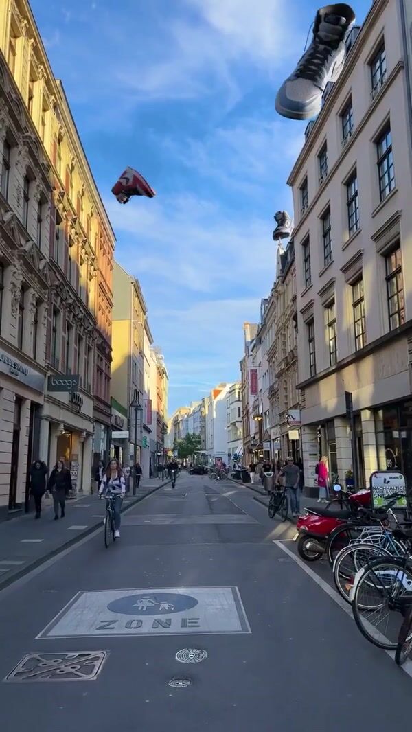 Coziness Giant Sneakers Float Above Cologne Street