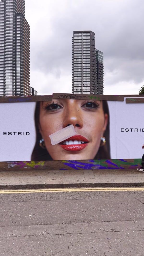Estrid Woman Peels Adhesive Tape from Billboard