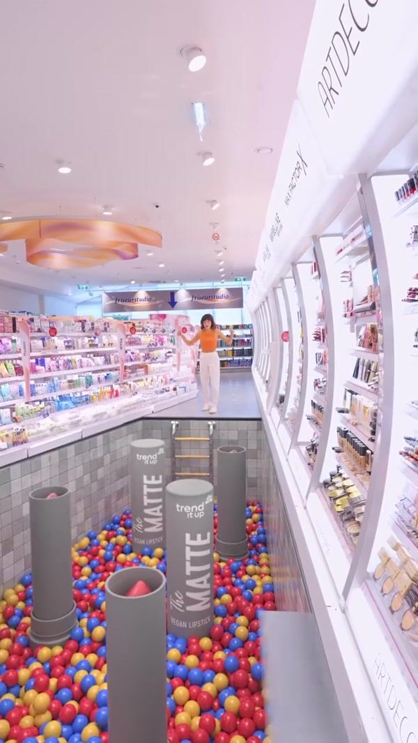 DM Woman Jumping on Lipsticks Above Ball Pit