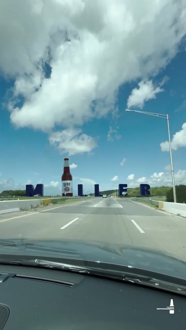 Miller Beer Bottle Stands Beside Highway