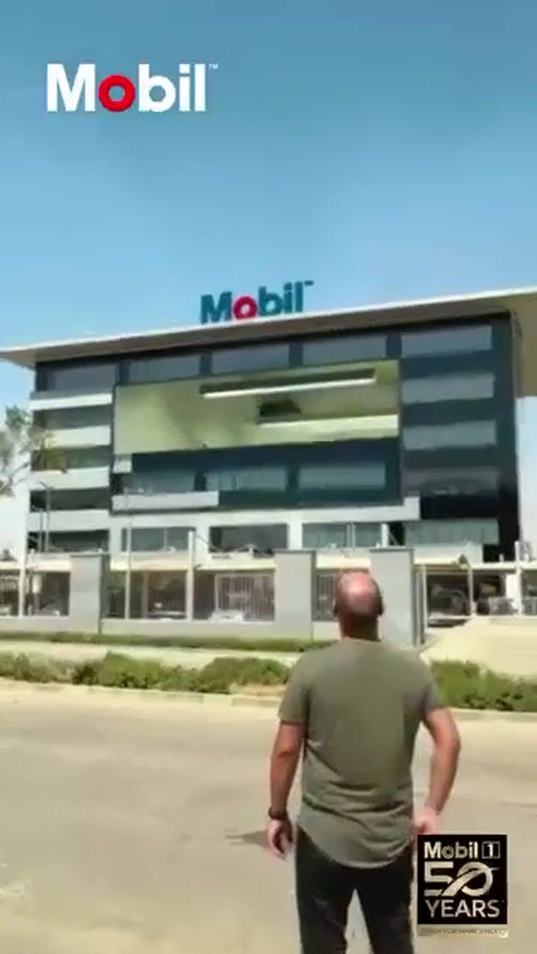 Mobil Building Facade Opens for Giant Oil Bottles
