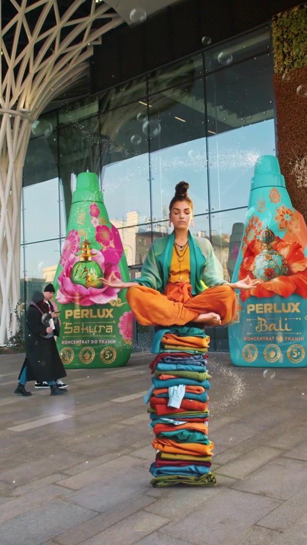 Perlux Giant Bottles Tower Behind Meditating Woman